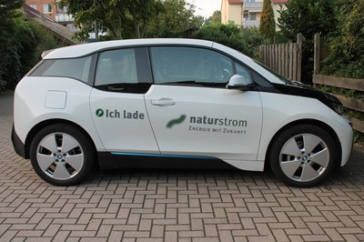 Weißes Elektroauto mit naturstrom-Aufklebern "ich lade naturstrom"
